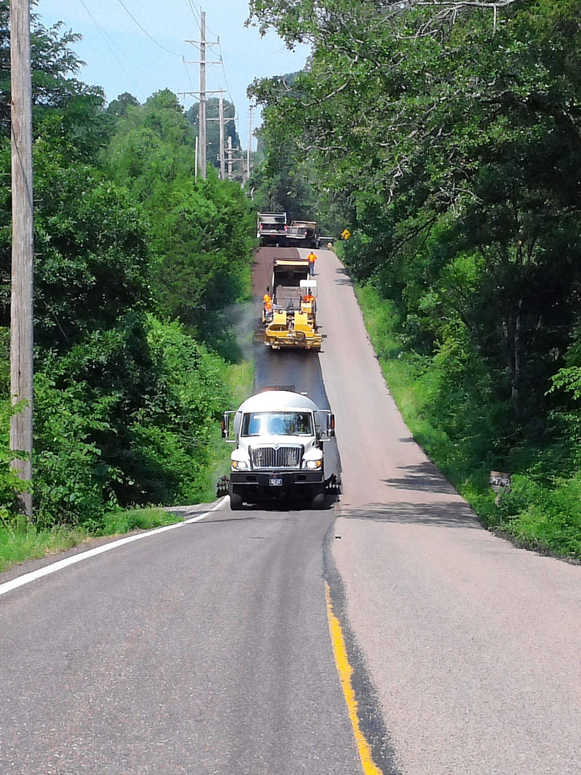 Equipment placing oil on roadway